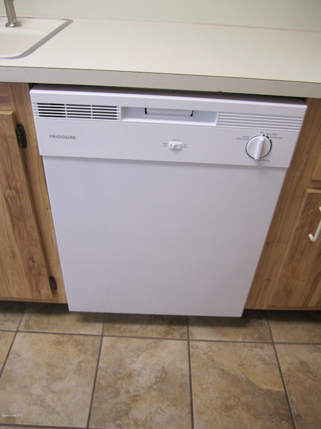 details featuring light tile patterned floors, white dishwasher, and sink