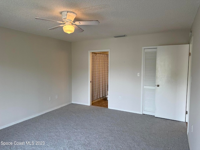 unfurnished bedroom featuring a textured ceiling, carpet, and ceiling fan