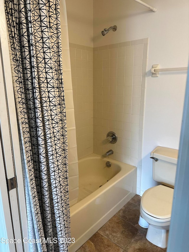 bathroom with shower / bath combo, toilet, and tile patterned floors