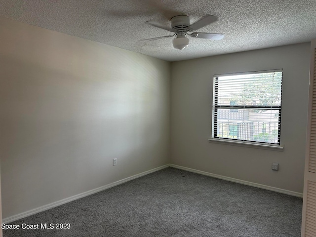 carpeted spare room featuring ceiling fan and a textured ceiling