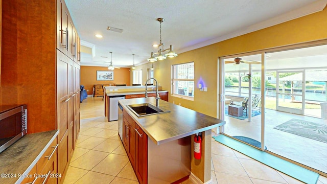 kitchen featuring ceiling fan with notable chandelier, a center island with sink, hanging light fixtures, sink, and light tile patterned flooring