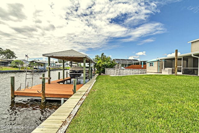 view of dock with a water view, a lawn, and a lanai