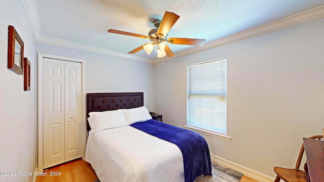 bedroom featuring a textured ceiling, ceiling fan, a closet, and wood-type flooring