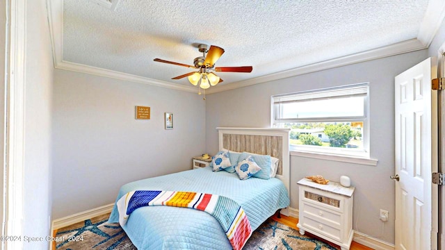 bedroom with ornamental molding, a textured ceiling, hardwood / wood-style flooring, and ceiling fan