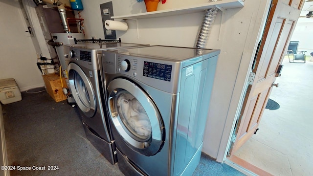 clothes washing area featuring washer and clothes dryer and water heater