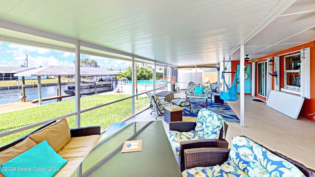 sunroom / solarium featuring a water view