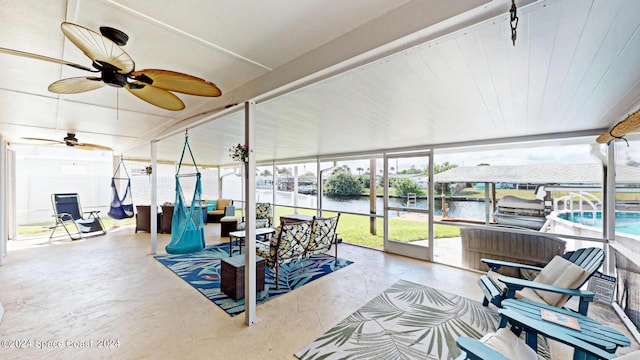 sunroom / solarium featuring a water view and ceiling fan