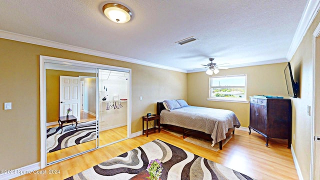 bedroom featuring ceiling fan, light hardwood / wood-style floors, crown molding, and a textured ceiling