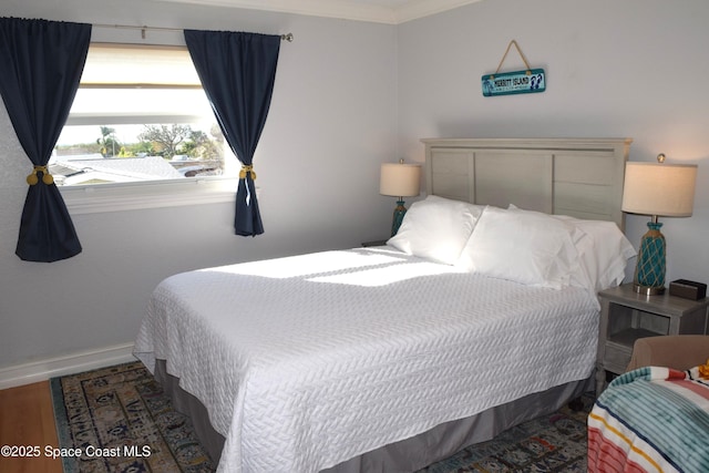 bedroom with baseboards and wood finished floors