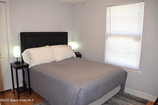 bedroom featuring wood finished floors and baseboards