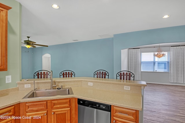 kitchen featuring hanging light fixtures, sink, wood-type flooring, dishwasher, and ceiling fan with notable chandelier