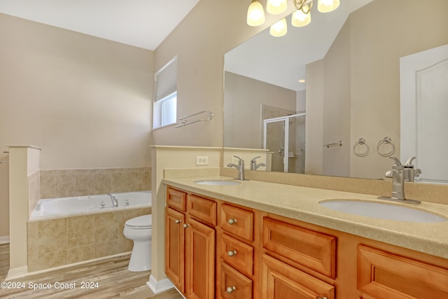 full bathroom with wood-type flooring, independent shower and bath, vanity, and toilet