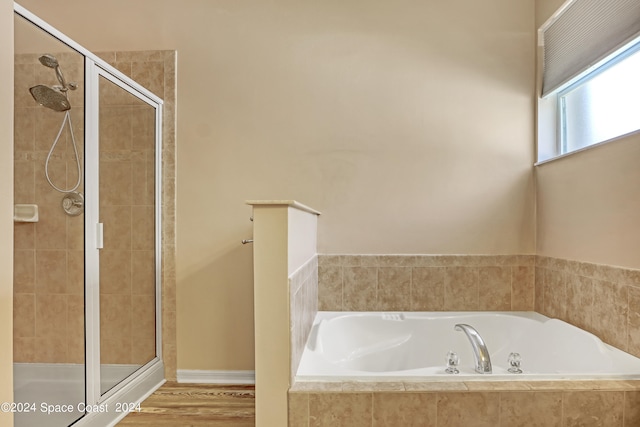 bathroom featuring wood-type flooring and plus walk in shower