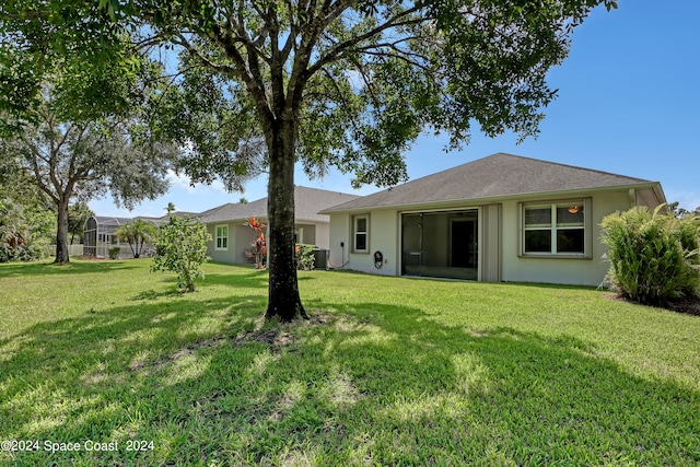 back of property featuring a lawn and cooling unit