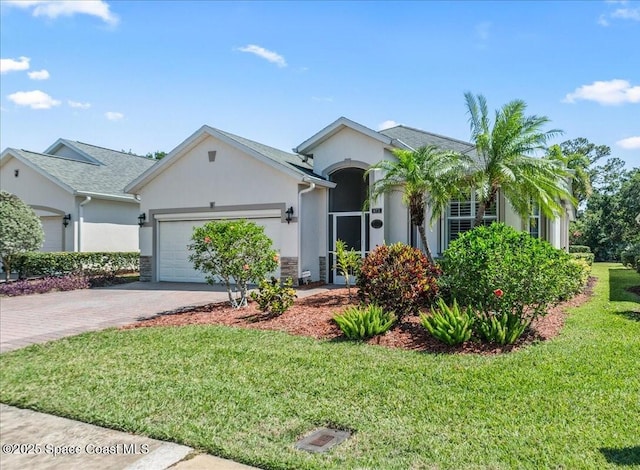 673 Remington Green Dr SE, Palm Bay, FL 32909 - single story home with a front lawn, a garage, decorative driveway, and stucco siding
