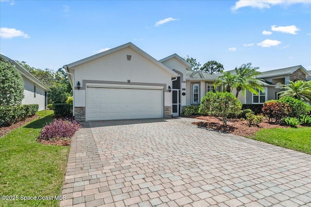 673 Remington Green Dr SE, Palm Bay, FL 32909 - ranch-style house with an attached garage, stone siding, stucco siding, a front lawn, and decorative driveway