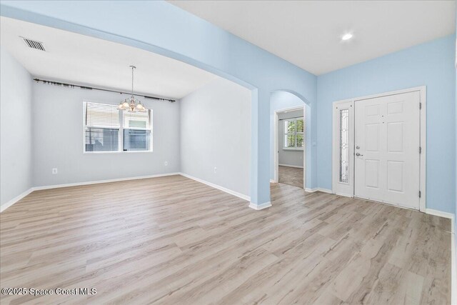 673 Remington Green Dr SE, Palm Bay, FL 32909 - entrance foyer featuring visible vents, baseboards, arched walkways, an inviting chandelier, and light wood-style floors