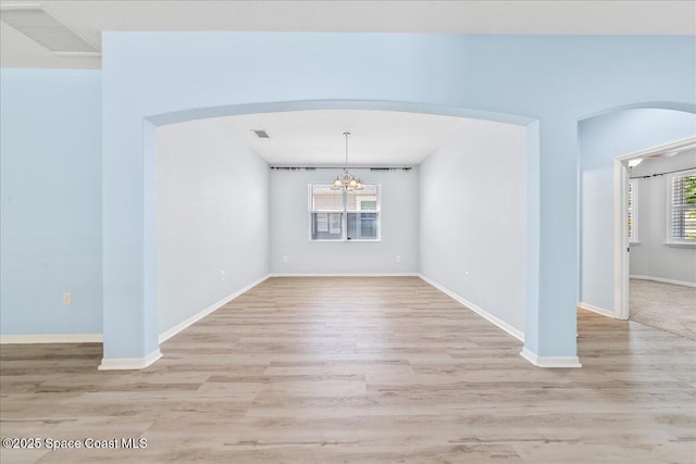 673 Remington Green Dr SE, Palm Bay, FL 32909 - unfurnished dining area featuring visible vents, baseboards, arched walkways, a chandelier, and wood finished floors