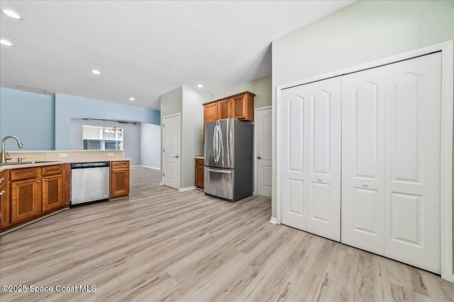 673 Remington Green Dr SE, Palm Bay, FL 32909 - kitchen with recessed lighting, brown cabinets, appliances with stainless steel finishes, light wood finished floors, and a sink