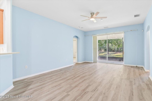 673 Remington Green Dr SE, Palm Bay, FL 32909 - empty room featuring visible vents, baseboards, arched walkways, a ceiling fan, and light wood-style floors