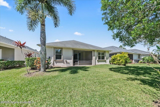 673 Remington Green Dr SE, Palm Bay, FL 32909 - rear view of house featuring stucco siding, a sunroom, and a lawn