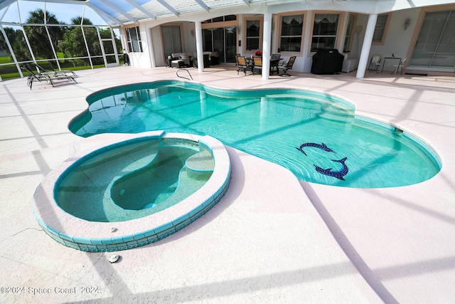 view of swimming pool with a lanai, a patio area, and an in ground hot tub