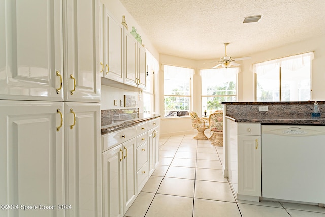 kitchen featuring white dishwasher, ceiling fan, white cabinets, and a textured ceiling