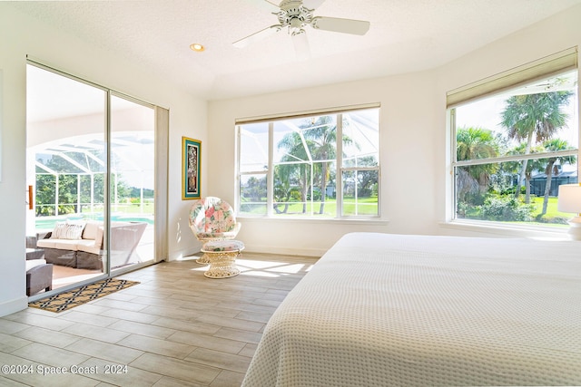 bedroom with access to exterior, ceiling fan, light hardwood / wood-style flooring, and multiple windows