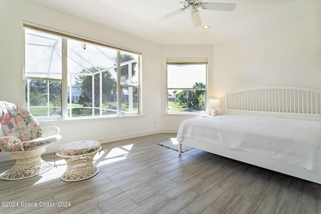 bedroom featuring ceiling fan, hardwood / wood-style flooring, and a textured ceiling