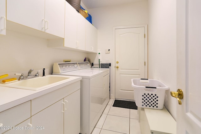 laundry area with light tile patterned floors, independent washer and dryer, cabinets, and sink