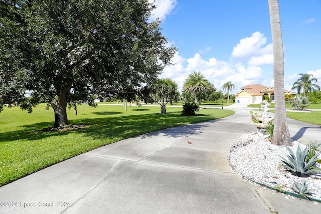 view of property's community with a lawn and a garage