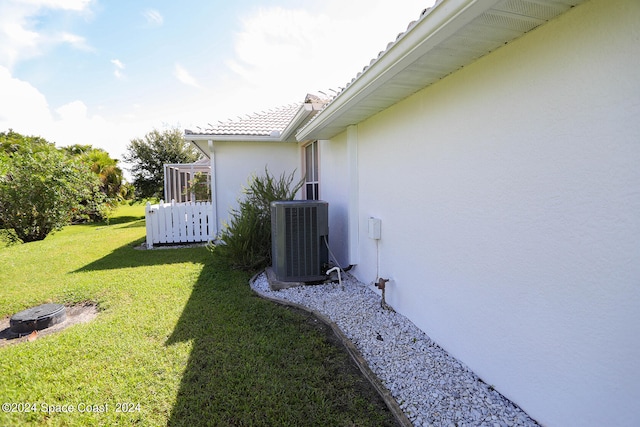 view of home's exterior featuring a yard and central AC unit