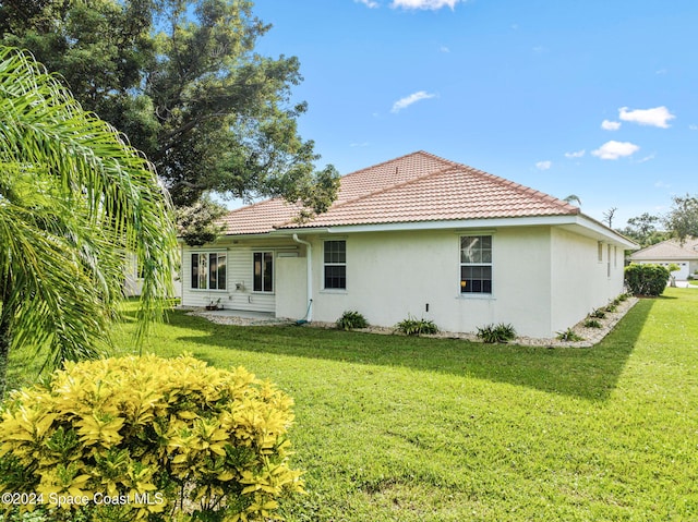 rear view of property featuring a yard