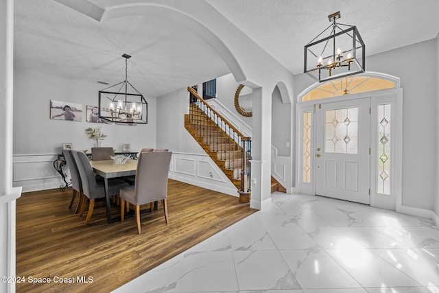 dining area with hardwood / wood-style flooring, a chandelier, and a textured ceiling