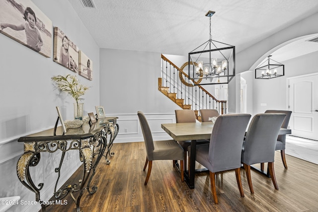 dining area with a chandelier, hardwood / wood-style floors, and a textured ceiling