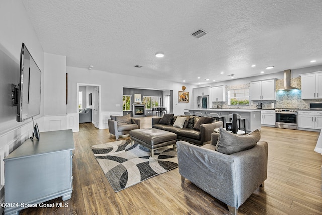 living room with light wood-type flooring and a textured ceiling