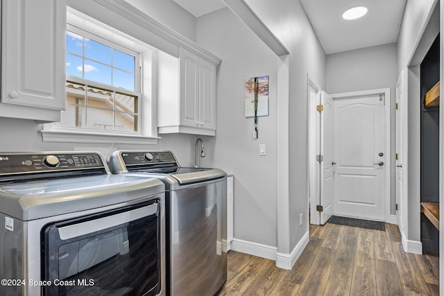 laundry room featuring cabinets, separate washer and dryer, and dark hardwood / wood-style flooring