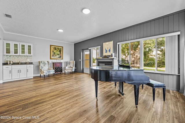 misc room featuring light hardwood / wood-style flooring, a textured ceiling, and crown molding