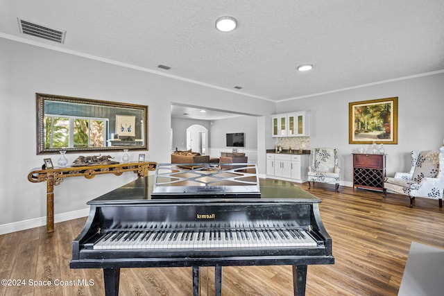 misc room featuring hardwood / wood-style floors, a textured ceiling, and crown molding