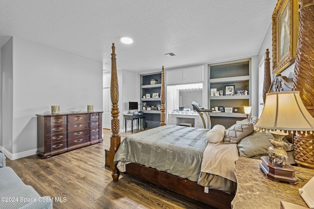 bedroom with hardwood / wood-style floors and a textured ceiling