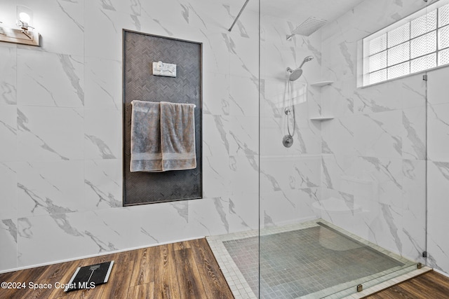 bathroom featuring hardwood / wood-style floors and a tile shower