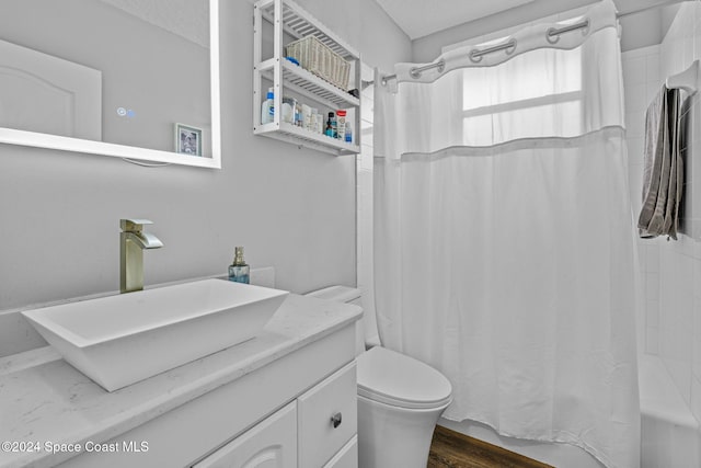 full bathroom featuring vanity, hardwood / wood-style flooring, toilet, and shower / tub combo with curtain