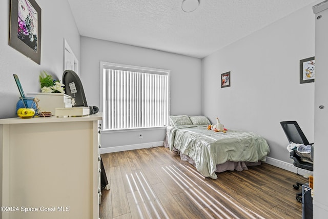 bedroom featuring a textured ceiling and hardwood / wood-style flooring