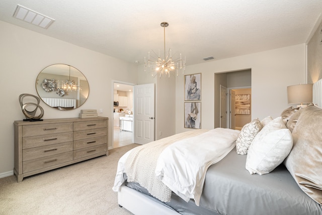 bedroom with a textured ceiling, light colored carpet, and an inviting chandelier