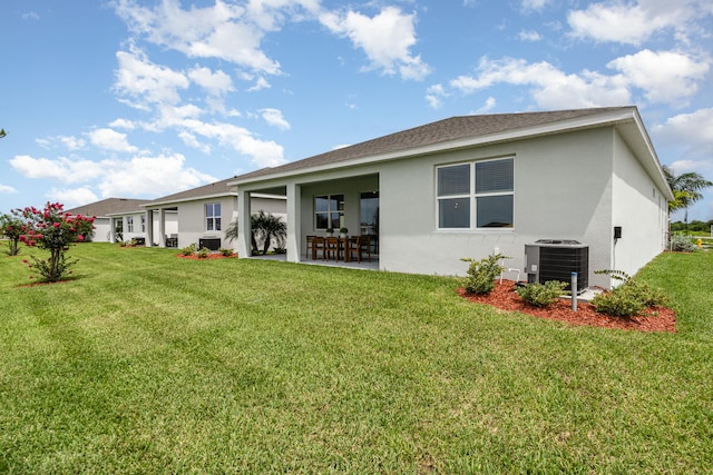 back of property featuring a lawn and cooling unit