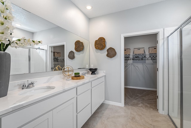 bathroom featuring vanity, tile patterned flooring, and a shower with shower door