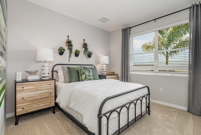 bedroom featuring baseboards, visible vents, and light colored carpet