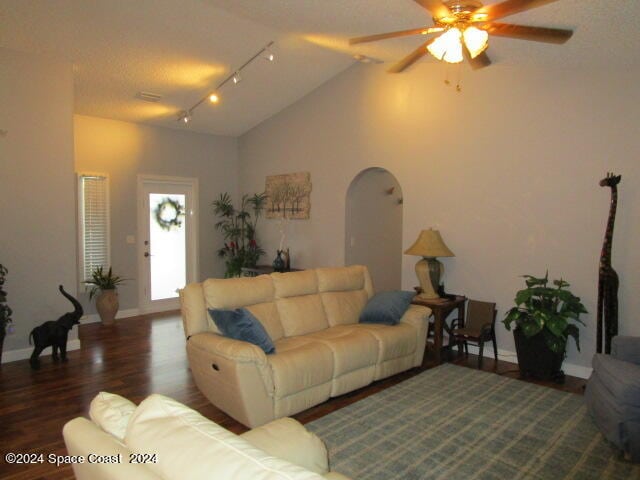 living room featuring hardwood / wood-style flooring, rail lighting, vaulted ceiling, a textured ceiling, and ceiling fan