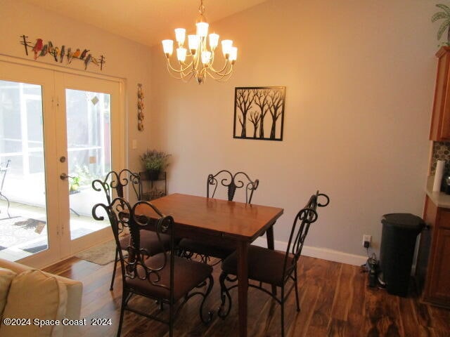 dining room with dark hardwood / wood-style flooring, french doors, and a chandelier