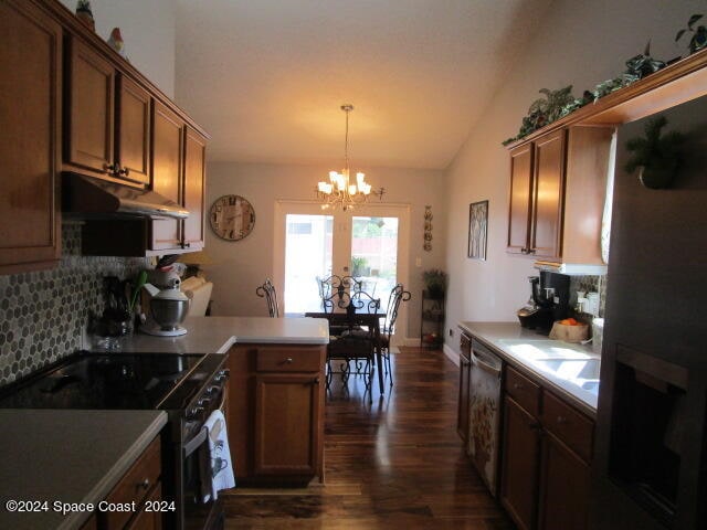 kitchen with decorative backsplash, an inviting chandelier, lofted ceiling, dark hardwood / wood-style flooring, and range with electric stovetop